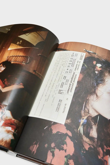 Fashion photography magazine spread with portrait of woman in floral dress and train ticket