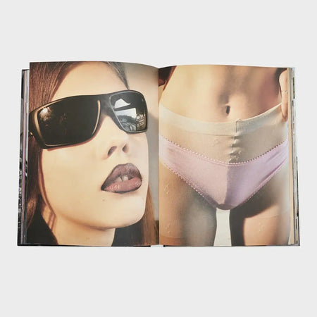 Open fashion photography book showing a woman in sunglasses and another in pastel underwear