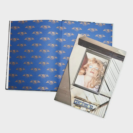 Fashion art photobook with a blue patterned interior and a cover featuring a woman portrait