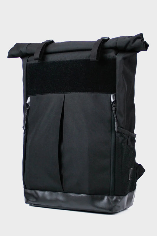 Black roll-top backpack with front pockets and side mesh panel on white background