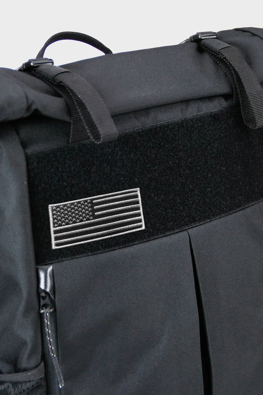 Black backpack with American flag patch, zippered pocket and adjustable straps